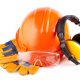 Orange hard hat, earphones, goggles and gloves on a white background